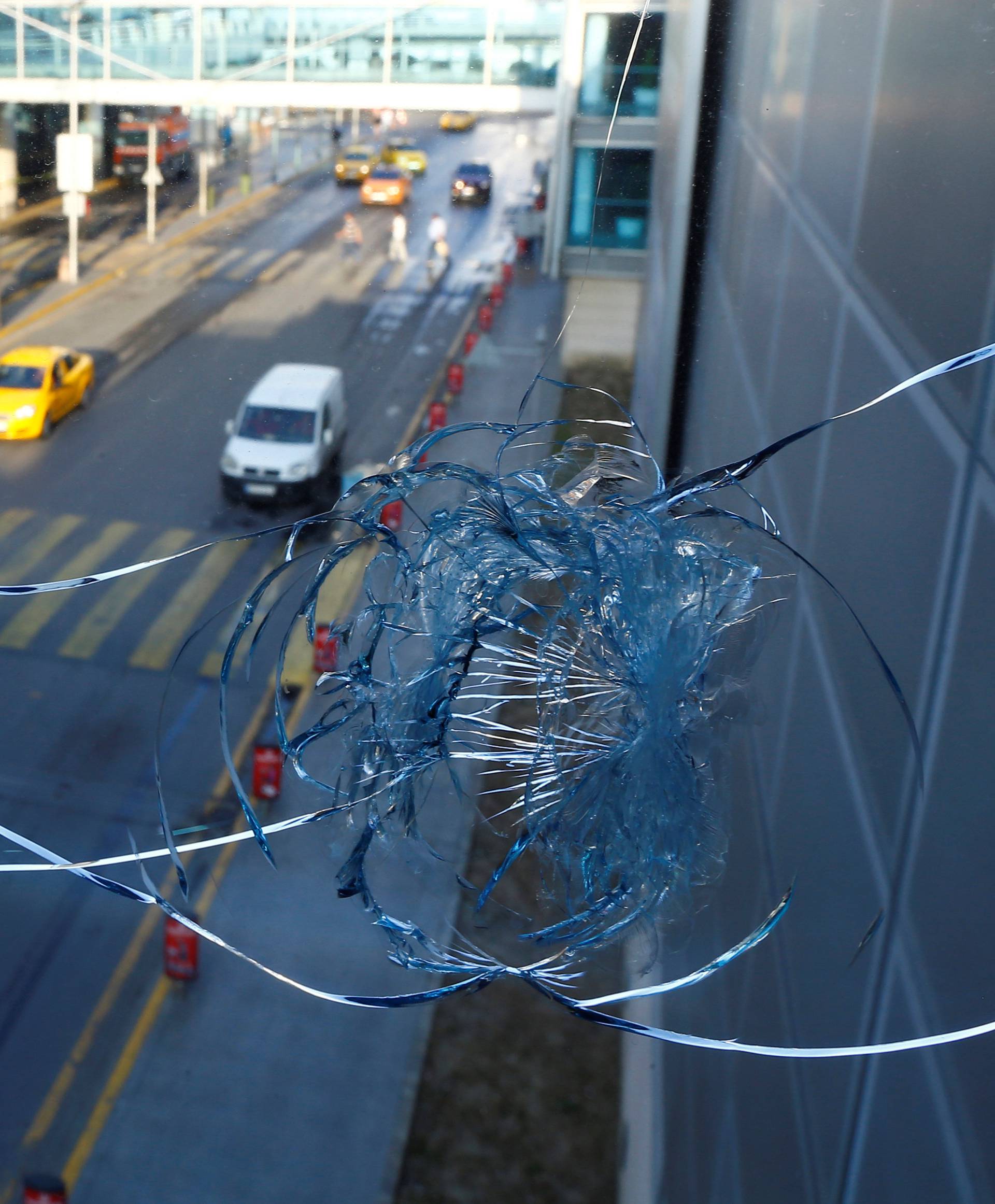 Vehicles are seen behind a broken window at Turkey's largest airport