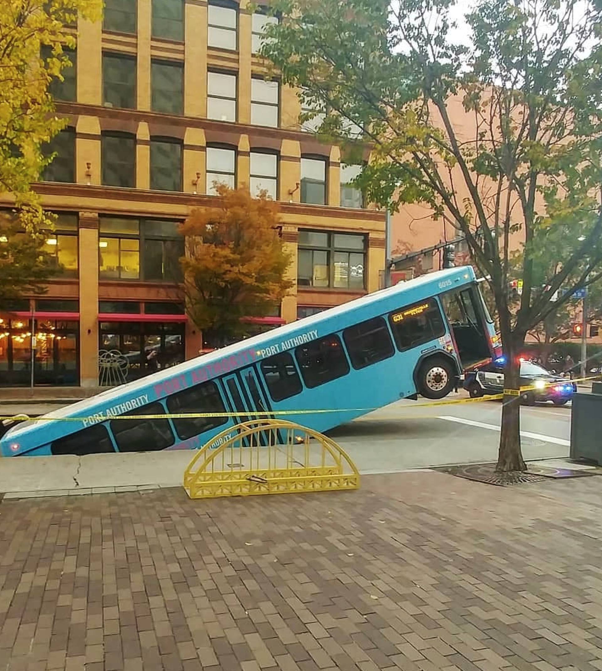 Front of a public bus sticks out of a sinkhole on 10th and Penn Avenue in Pittsburgh