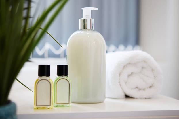 Hotel, lotion and bottle of soap in bathroom at luxury accommodation for travel, vacation or holiday. Hospitality, health and closeup of product placement in washroom at classy lodge for weekend trip