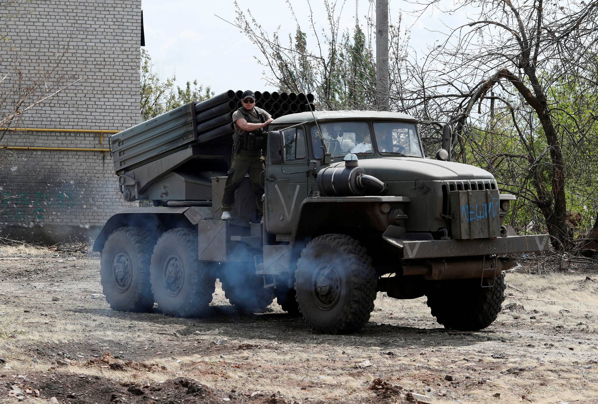 Service members of pro-Russian troops drive a BM-21 Grad multiple rocket launch system in Popasna