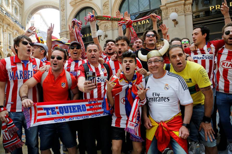 A Real Madrid fan poses with Atletico Madrid fans before the Champions League Final between Real Madrid and Atletico Madrid in Milan