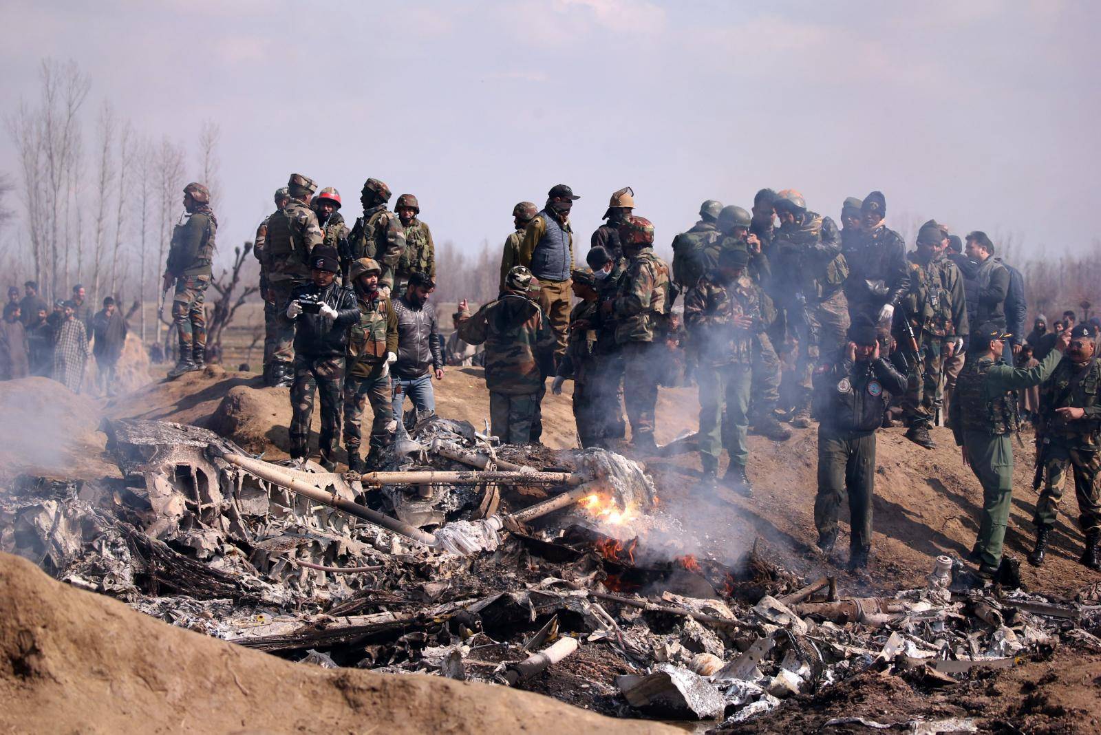 Indian soldiers stand next to the wreckage of Indian Air Force's helicopter after it crashed in Budgam district