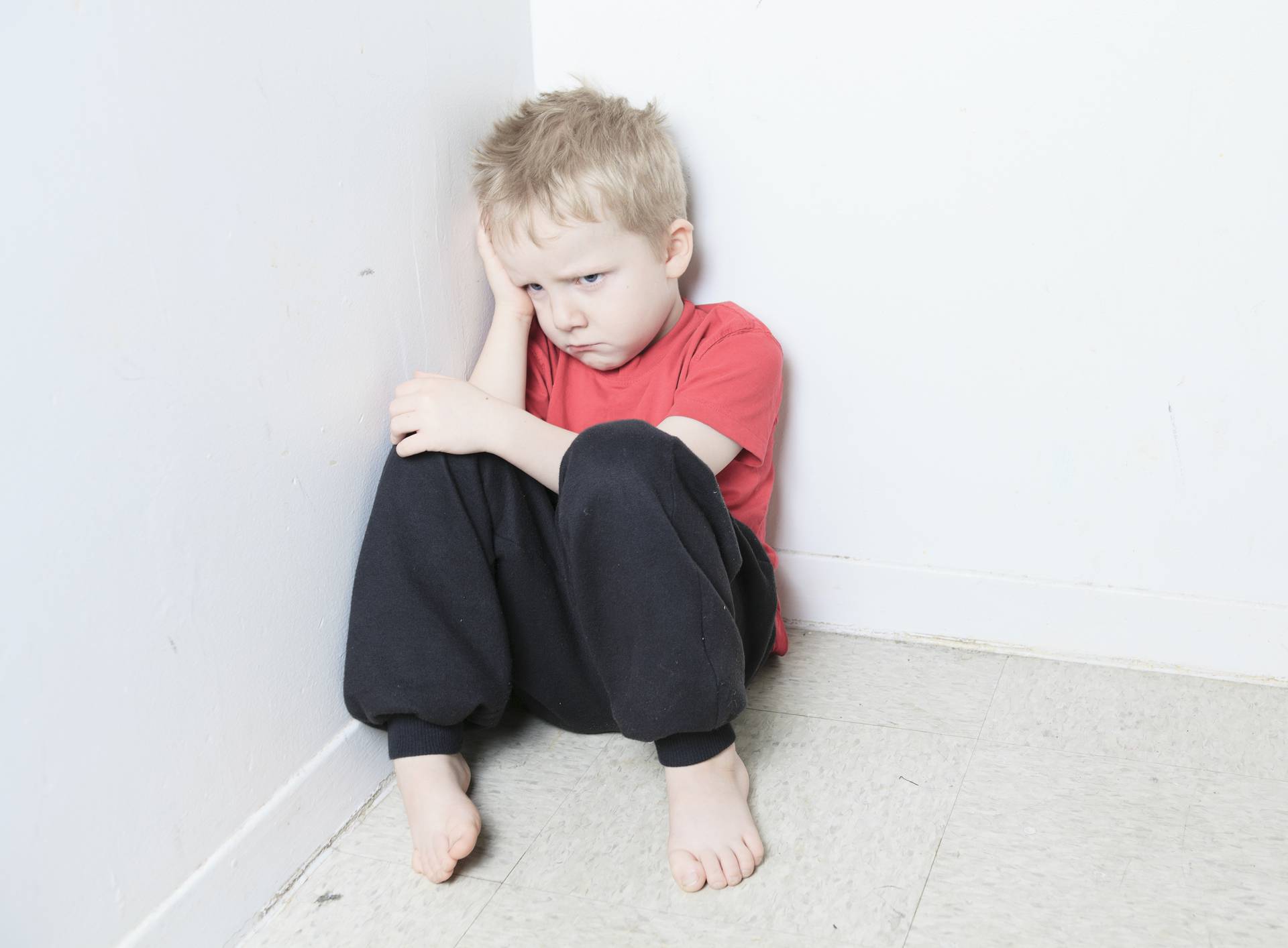 Neglected lonely child leaning at the wall