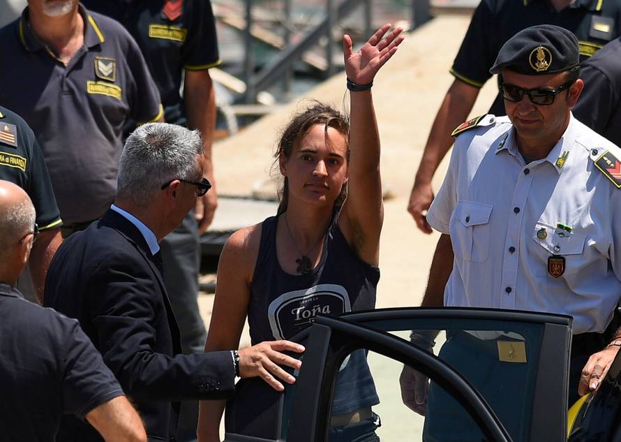 FILE PHOTO: Carola Rackete, the 31-year-old Sea-Watch 3 captain, disembarks from a Finance police boat and is escorted to a car, in Porto Empedocle