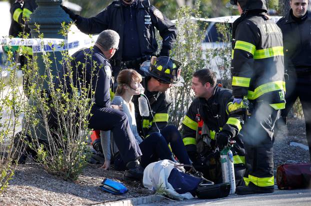 A woman is aided by first responders after sustaining injury on a bike path in lower Manhattan in New York