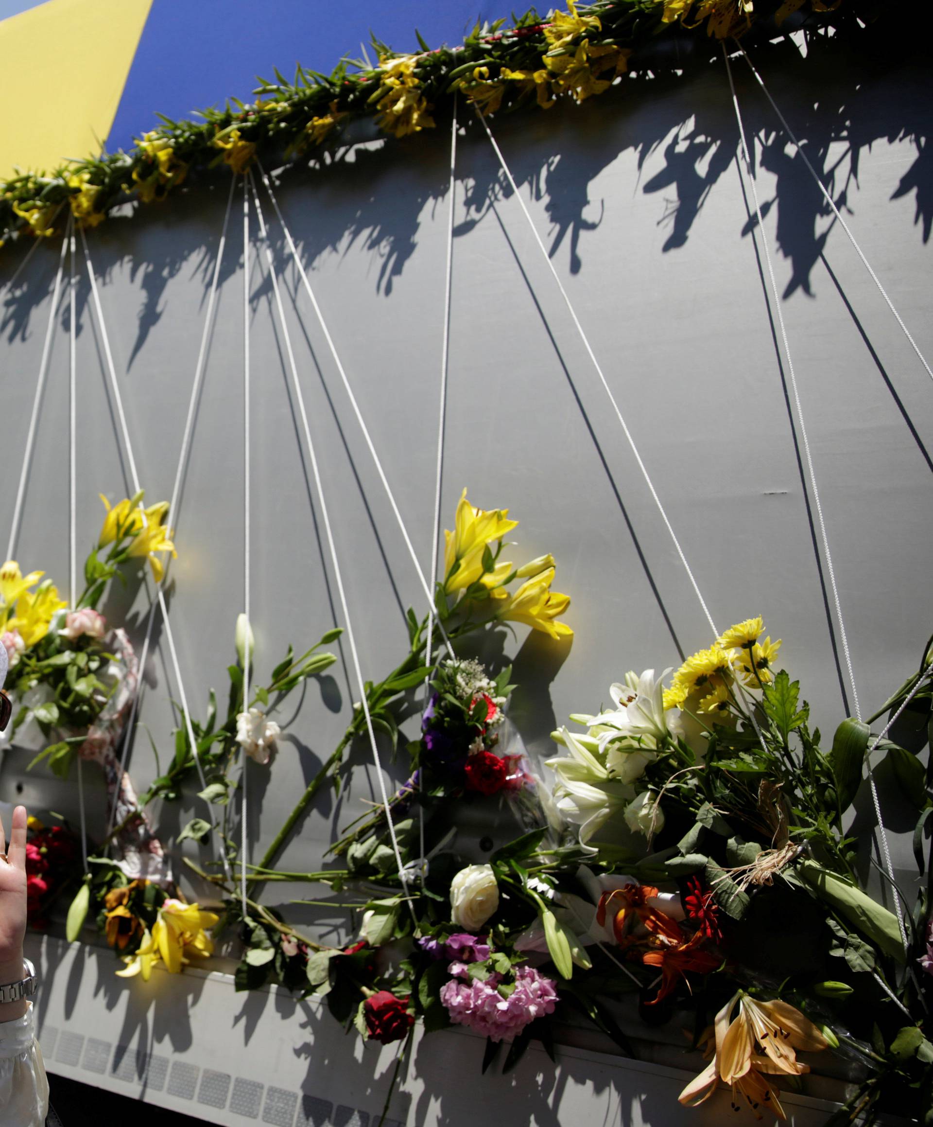 A woman reacts near a truck carrying coffins of newly identified victims of the 1995 Srebrenica massacre, in front of the presidential building in Sarajevo