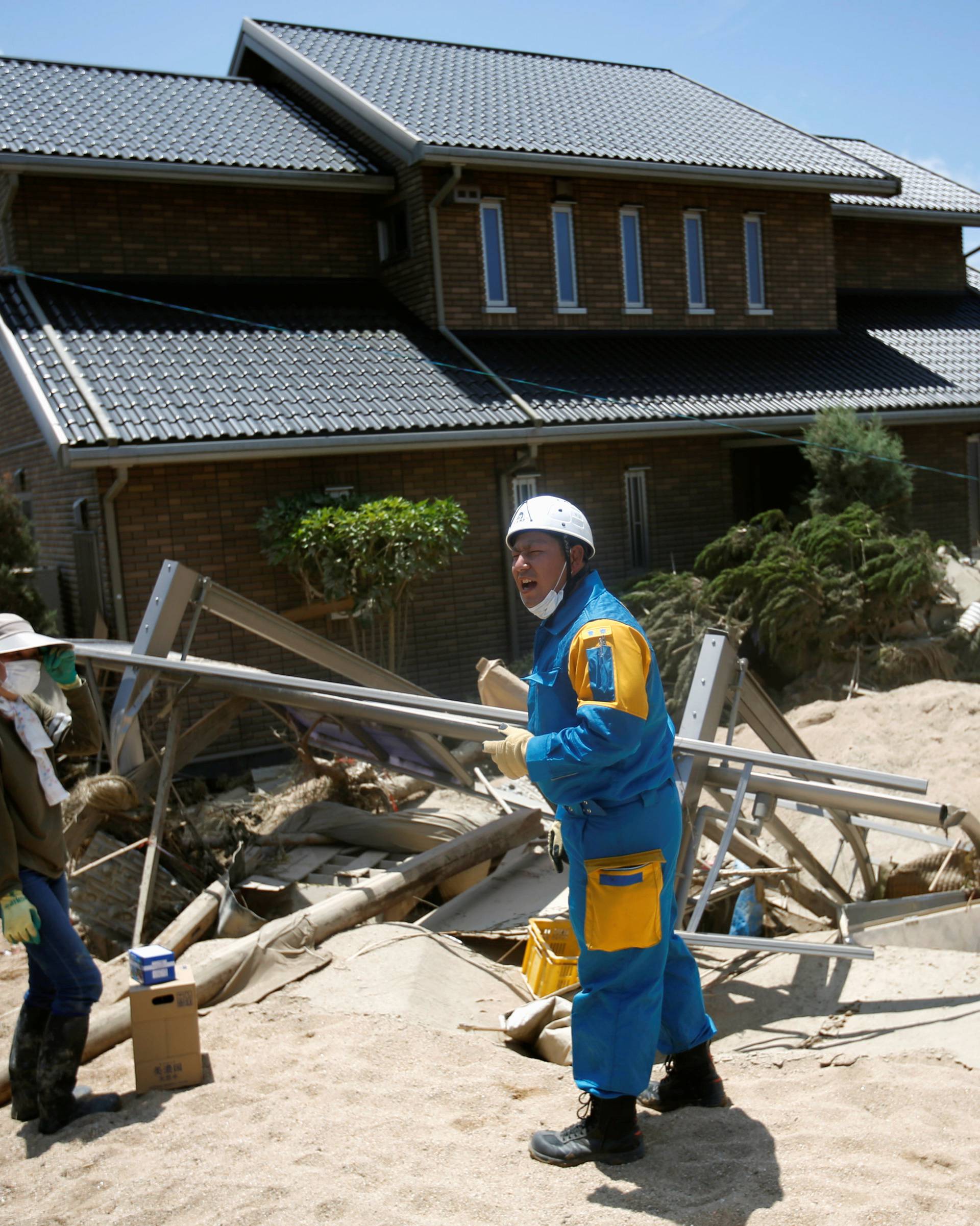 A police officer talks with a local resident in a flooded area in Mabi town in Kurashiki