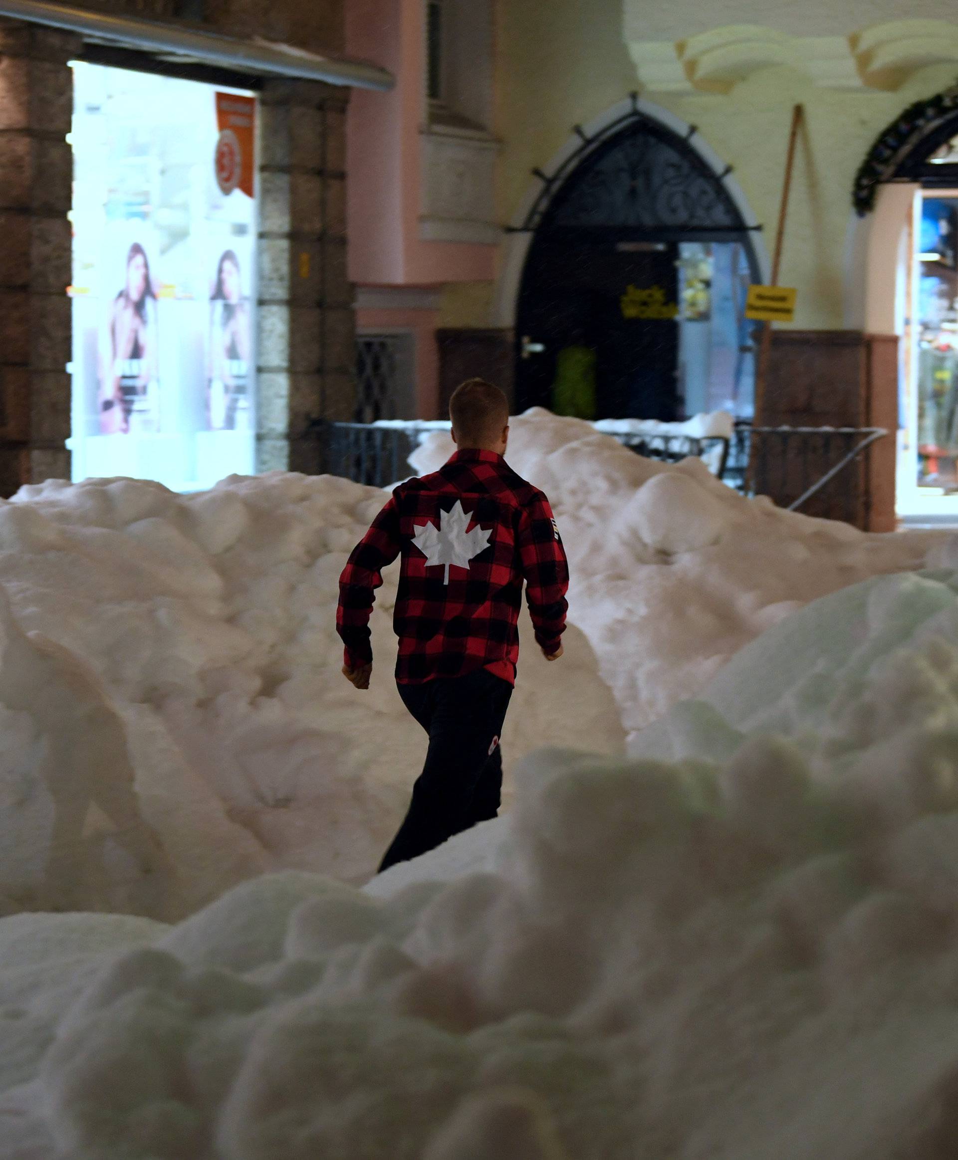A man walks through piles of snow