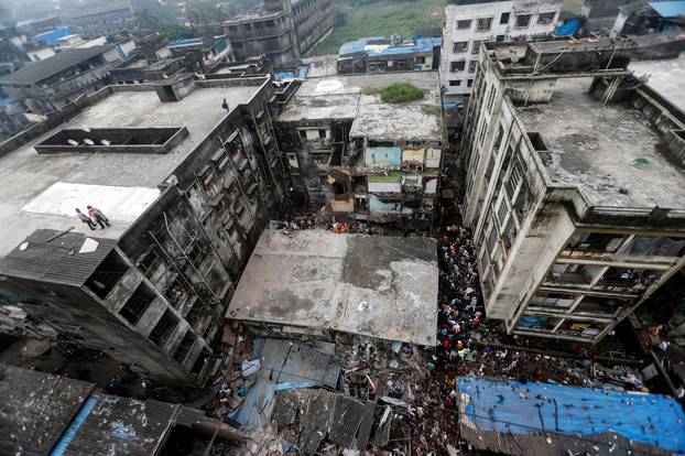 Rescue workers search for survivors from the debris after a three-storey residential building collapsed in Bhiwandi on the outskirts of Mumbai, India