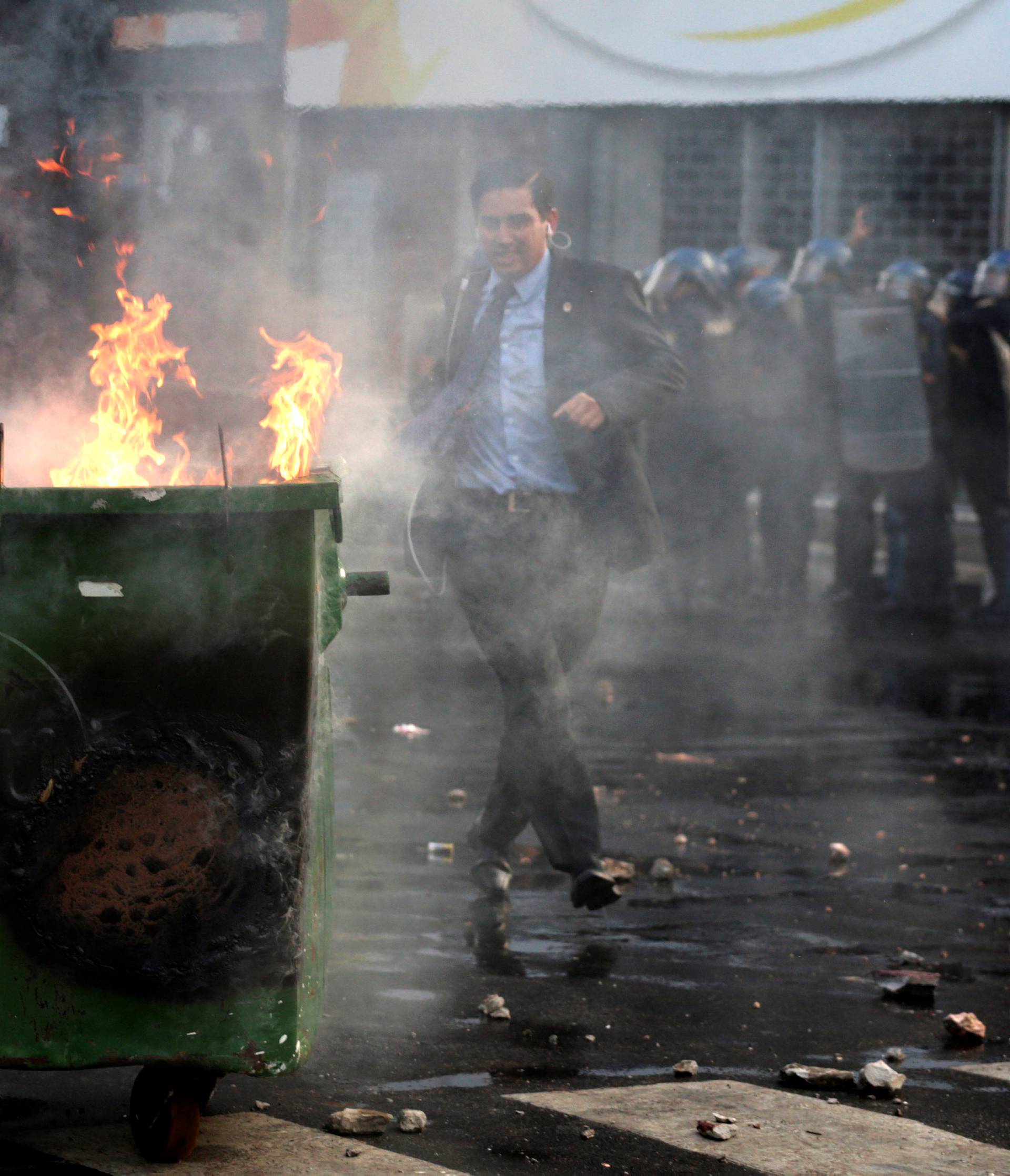 A journalist runs during a demonstration against a possible change in law to allow for presidential re-election in front of the Congress building in Asuncion