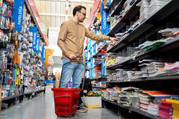 Adult,Man,Holding,A,Red,Shopping,Basket,,Picking,Out,Notebooks