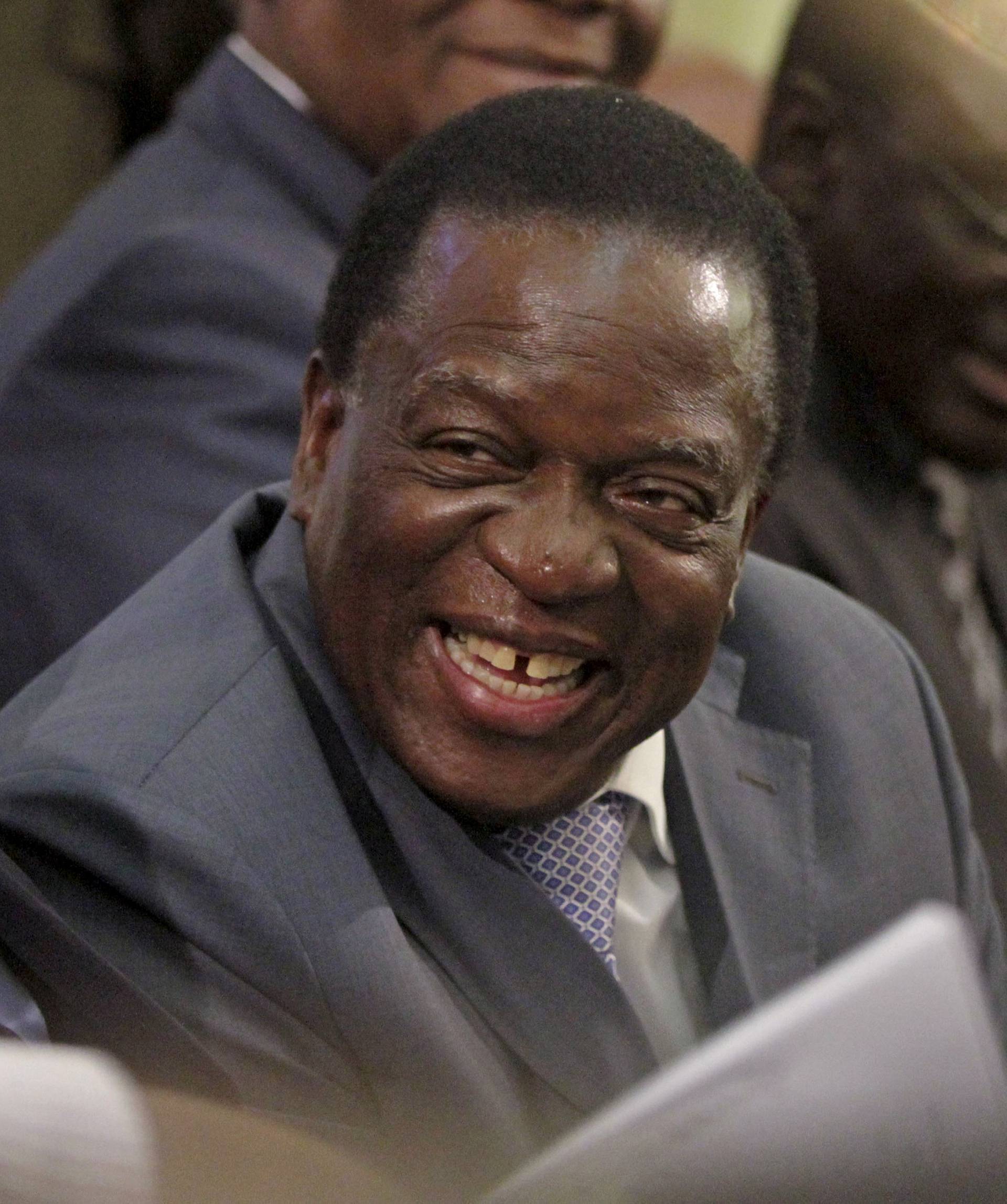 FILE PHOTO: Zimbabwe VP Mnangagwa listens as Mugabe delivers his state of the nation address to the country's parliament in Harare