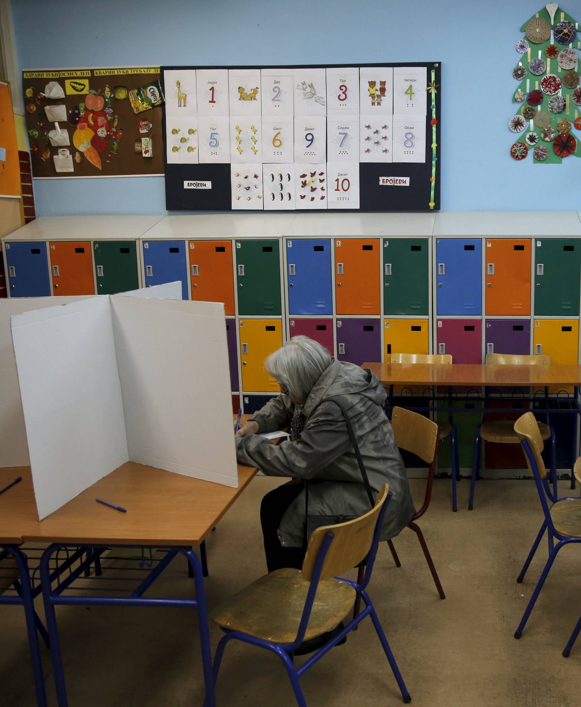 A woman casts her vote at a polling station during elections in Belgrade