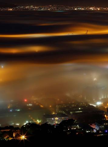 Seasonal fog is illuminated by the lights of  Cape Town harbour as the city prepares for the start of the southern hemisphere winter