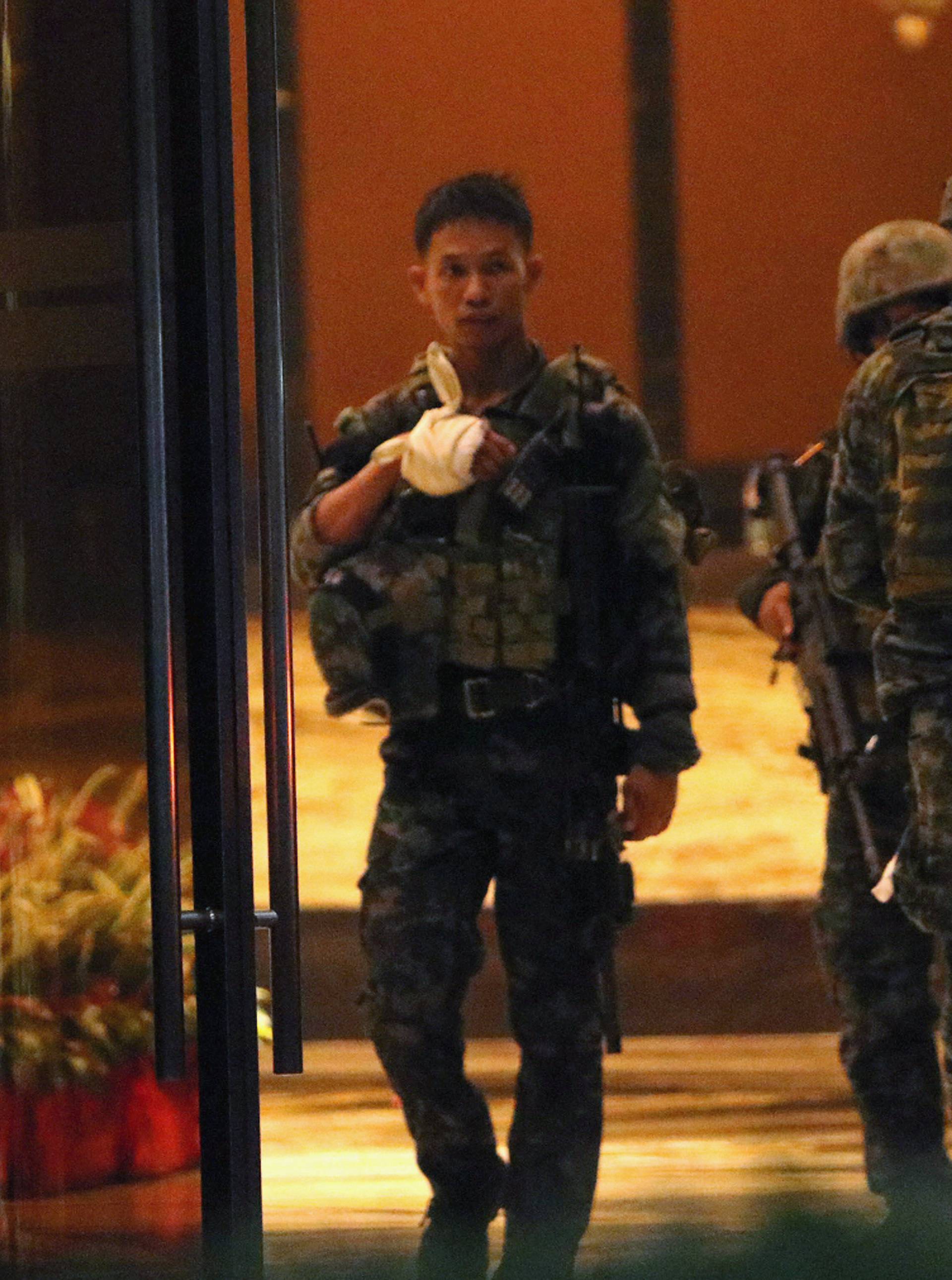 A injured policeman is seen at the entrance of a hotel after a shooting incident inside Resorts World Manila in Pasay City, Metro Manila