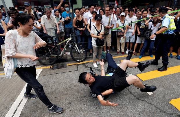 A police officer detains a demonstrator during a protest to demand authorities scrap a proposed extradition bill with China, in Hong Kong