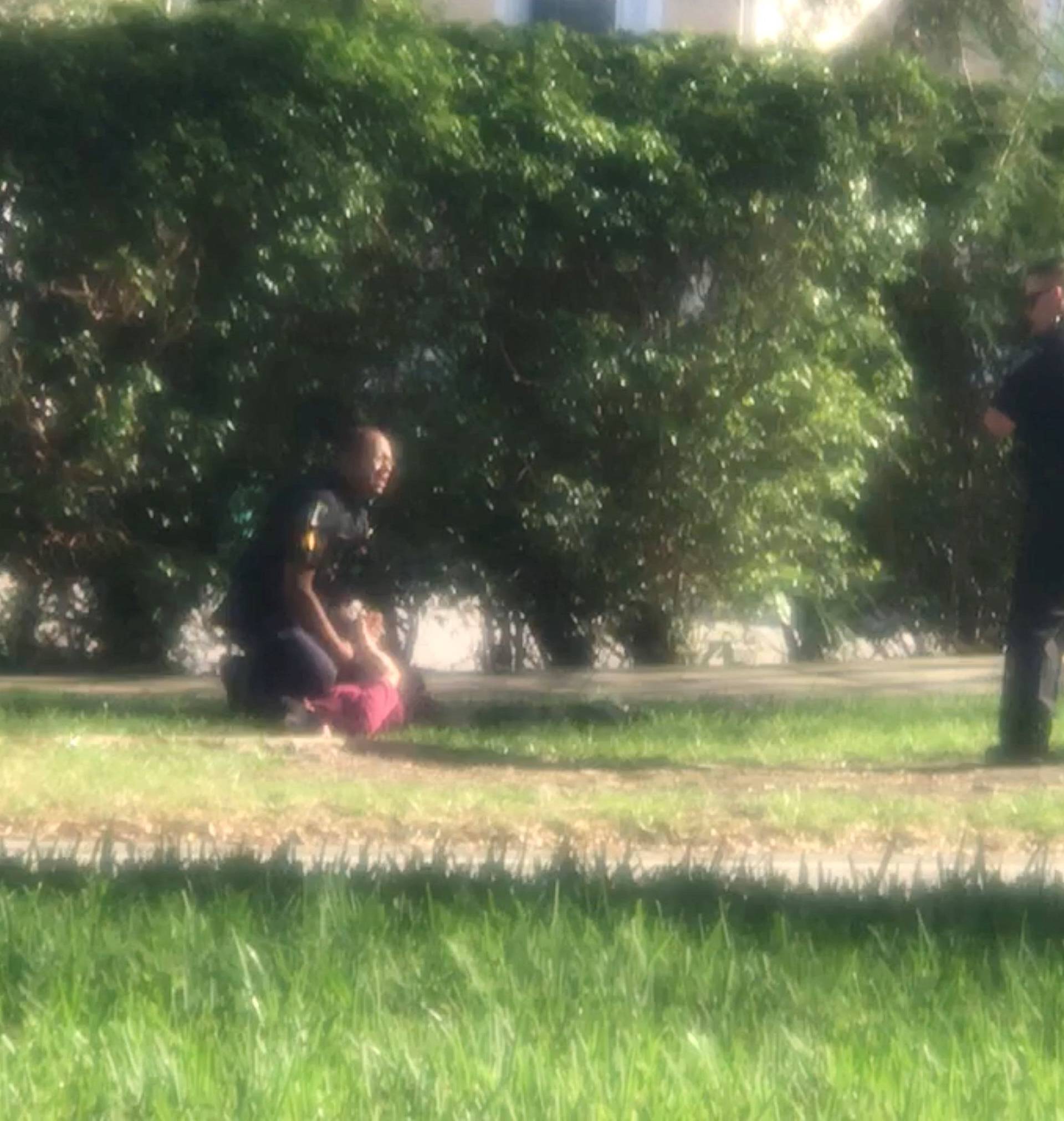 A man is placed in handcuffs by police officer, following a shooting incident in Parkland