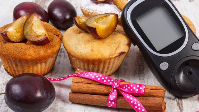 Glucometer, muffins with plums and cinnamon sticks, diabetes, delicious dessert