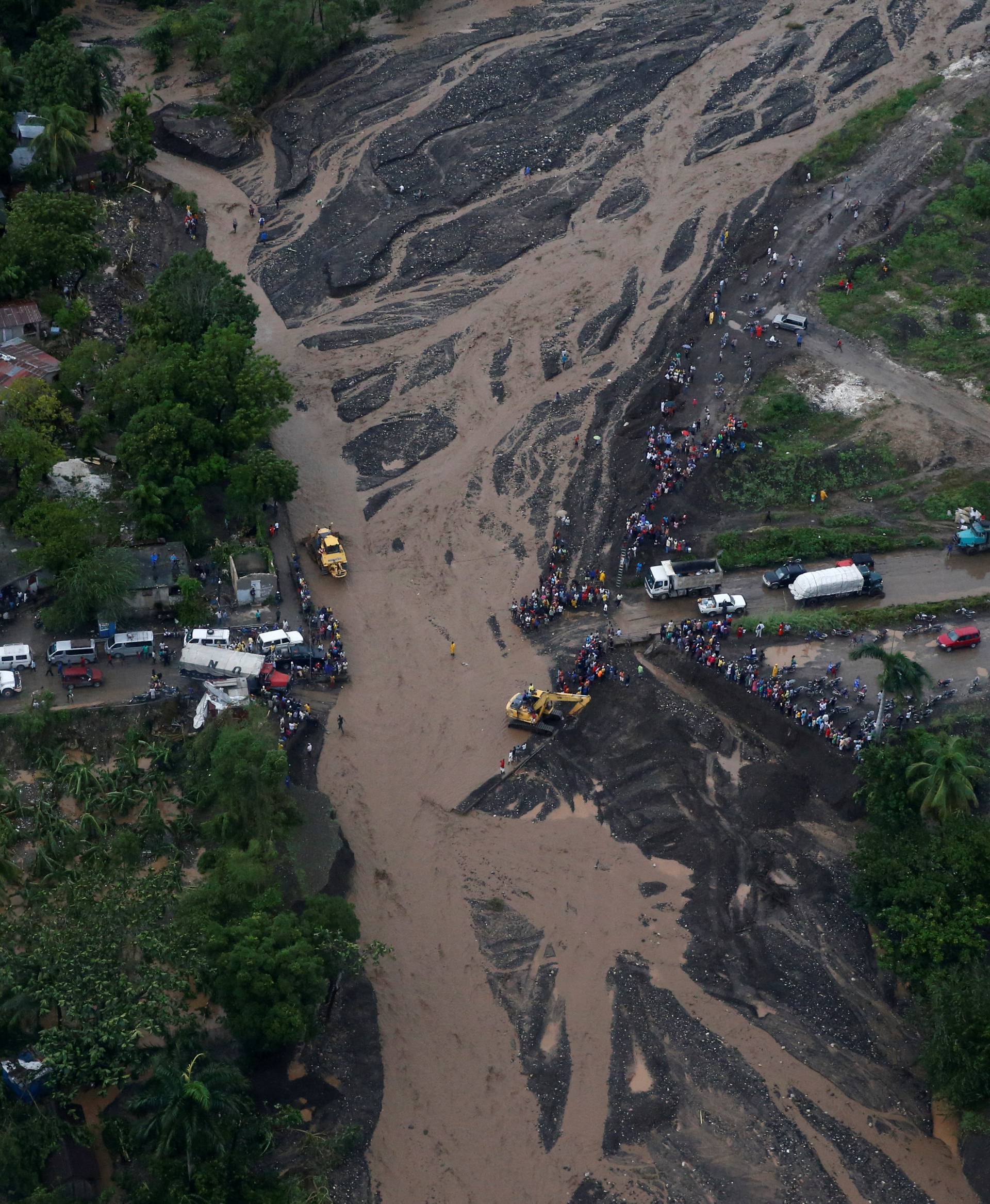 People gather next to a collapsed bridge after Hurricane Matthew passes Petit Goave, Haiti