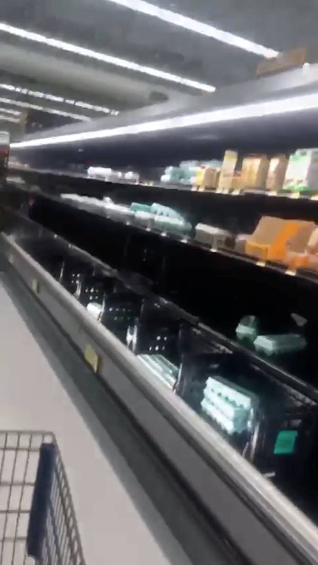 Half empty shelves are seen at a supermarket as residents prepare for Storm Florence