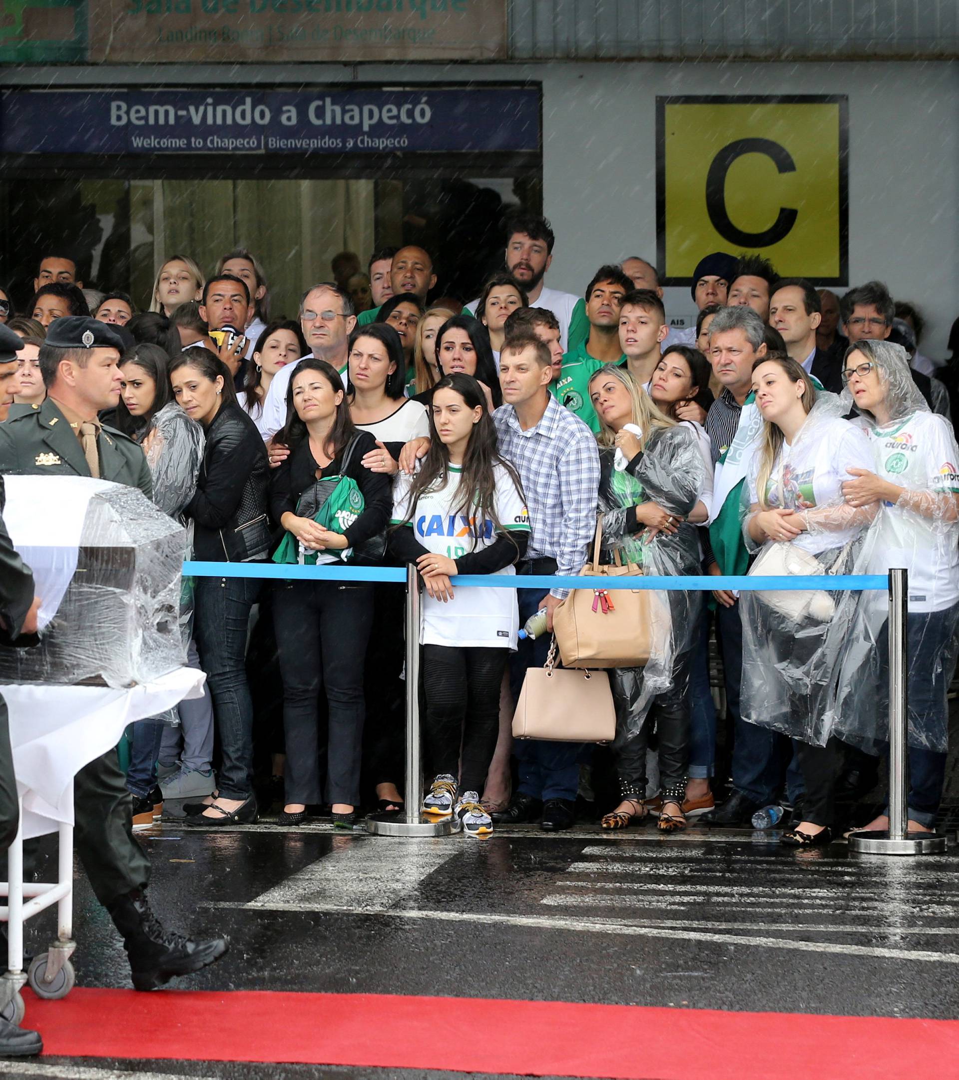 Relatives look on as a coffin cointaining the mortal remains of a victim of the plane crash in Colombia arrives in Chapeco