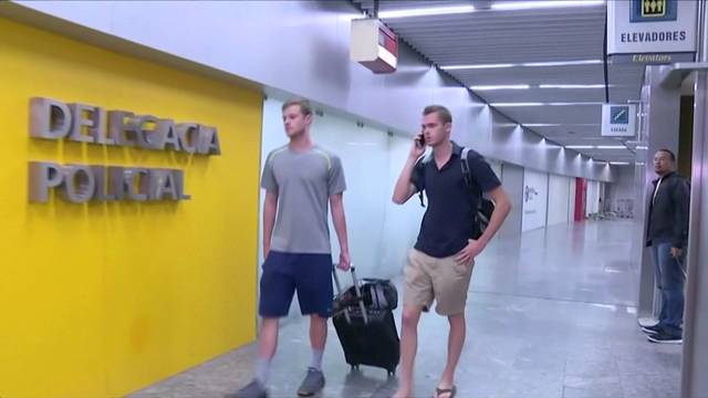 U.S. Olympic swimmers Gunnar Bentz and Jack Conger walk to the airport police station office at Rio's international airport in this still frame taken from video