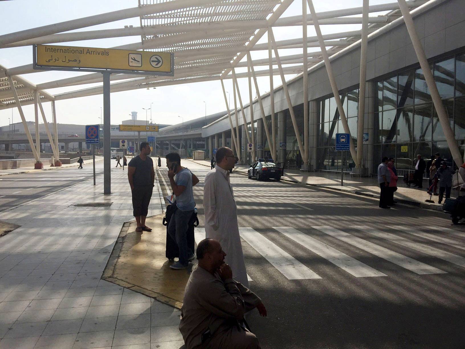 People wait outside the international arrivals terminal at Cairo Airport, Egypt