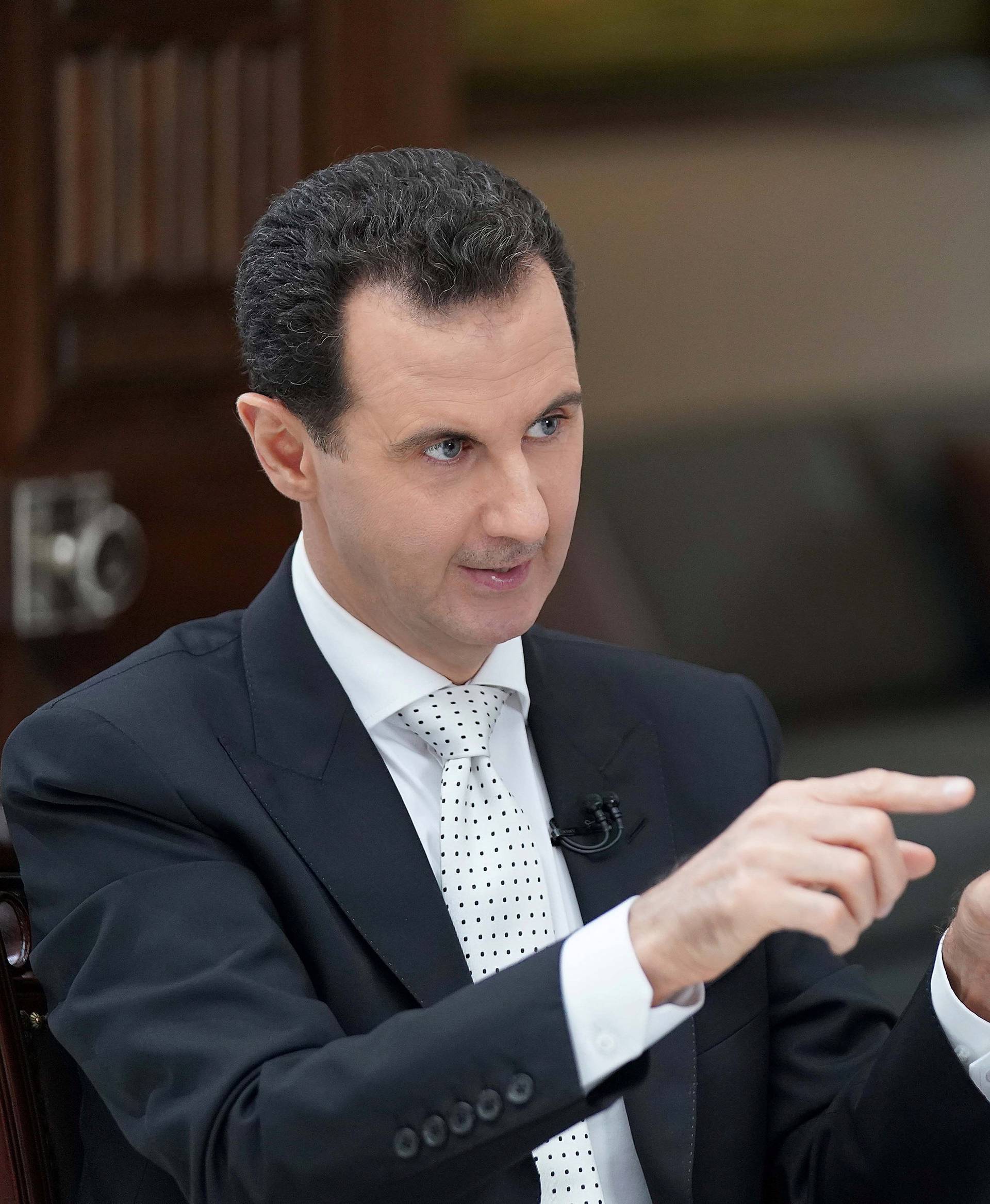 Syria's President Bashar al Assad gestures during an interview with a Greek newspaper in Damascus
