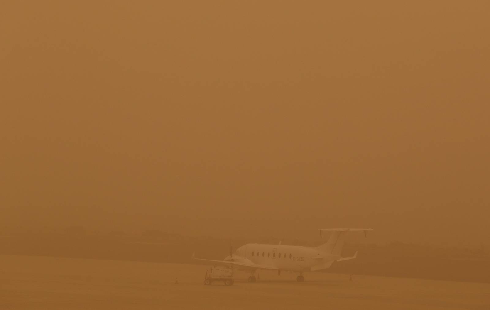 A plane is seen parked on a tarmac during a sandstorm blown over from North Africa known as "calima" at Las Palmas Airport