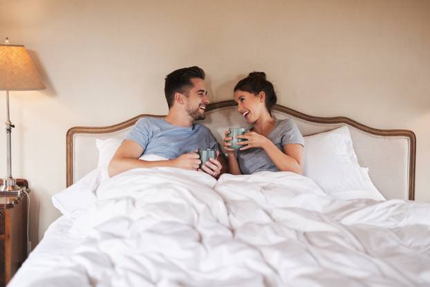 We always have something to chat about. a happy young couple drinking coffee in bed in their bedroom at home.