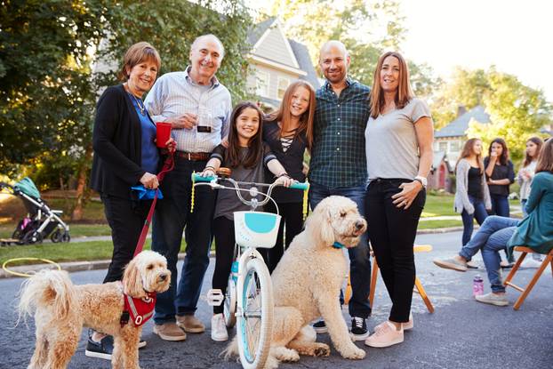 Neighbours,With,Pet,Dogs,Smiling,To,Camera,At,A,Block