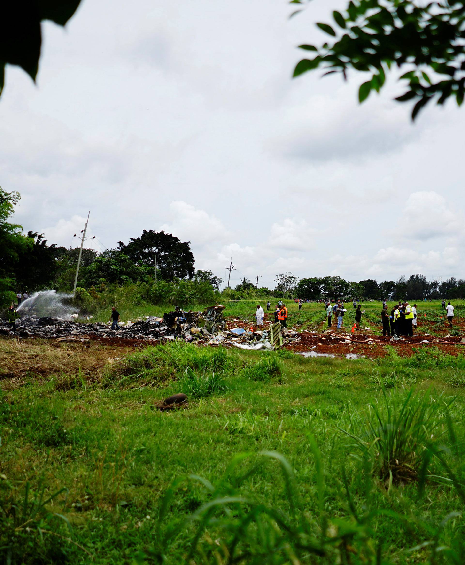 Rescue team members work in the wreckage of a Boeing 737 plane that crashed in the agricultural area of Boyeros