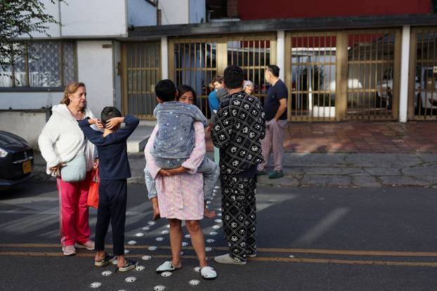 People gather outside a building following an earthquake in Bogota