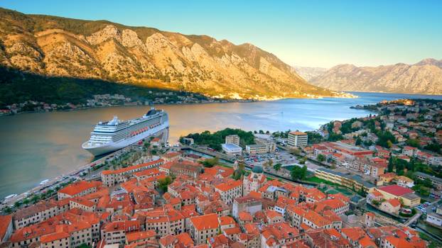 Skyline of Old Town, Kotor, Montenegro with Cruise Ship in Bay of Kotor, ship logos removed for commercial use