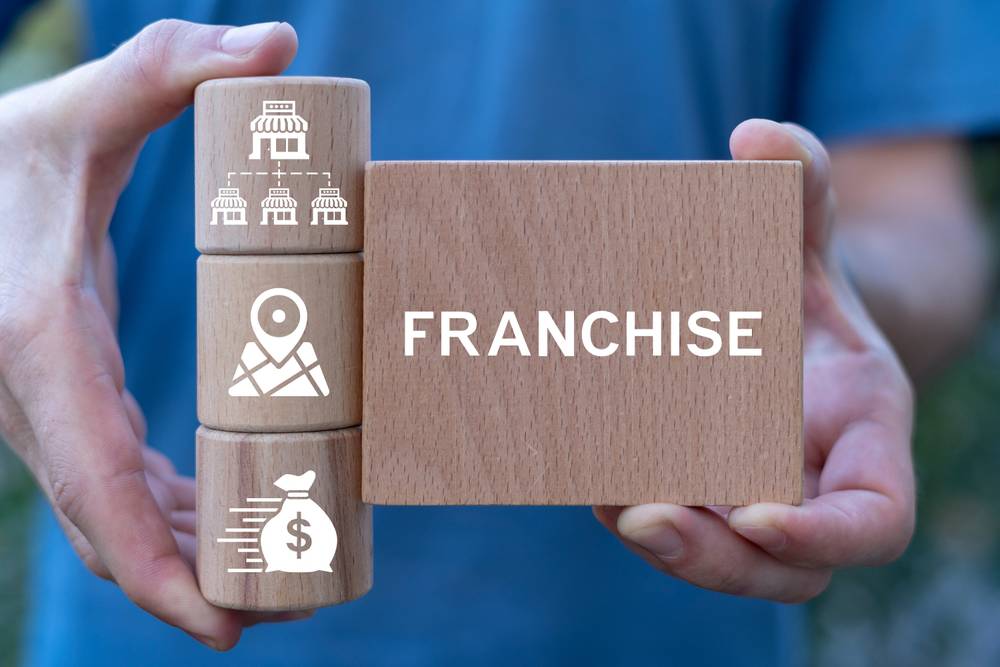 Man,Holding,Wooden,Blocks,Sees,Word:,Franchise.,Franchise,Business,Concept.