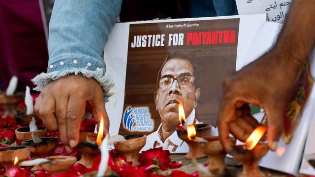 FILE PHOTO: People light oil lamps to express their condolences, following the lynching of the Sri Lankan manager of a garment factory in Sialkot, in Karachi