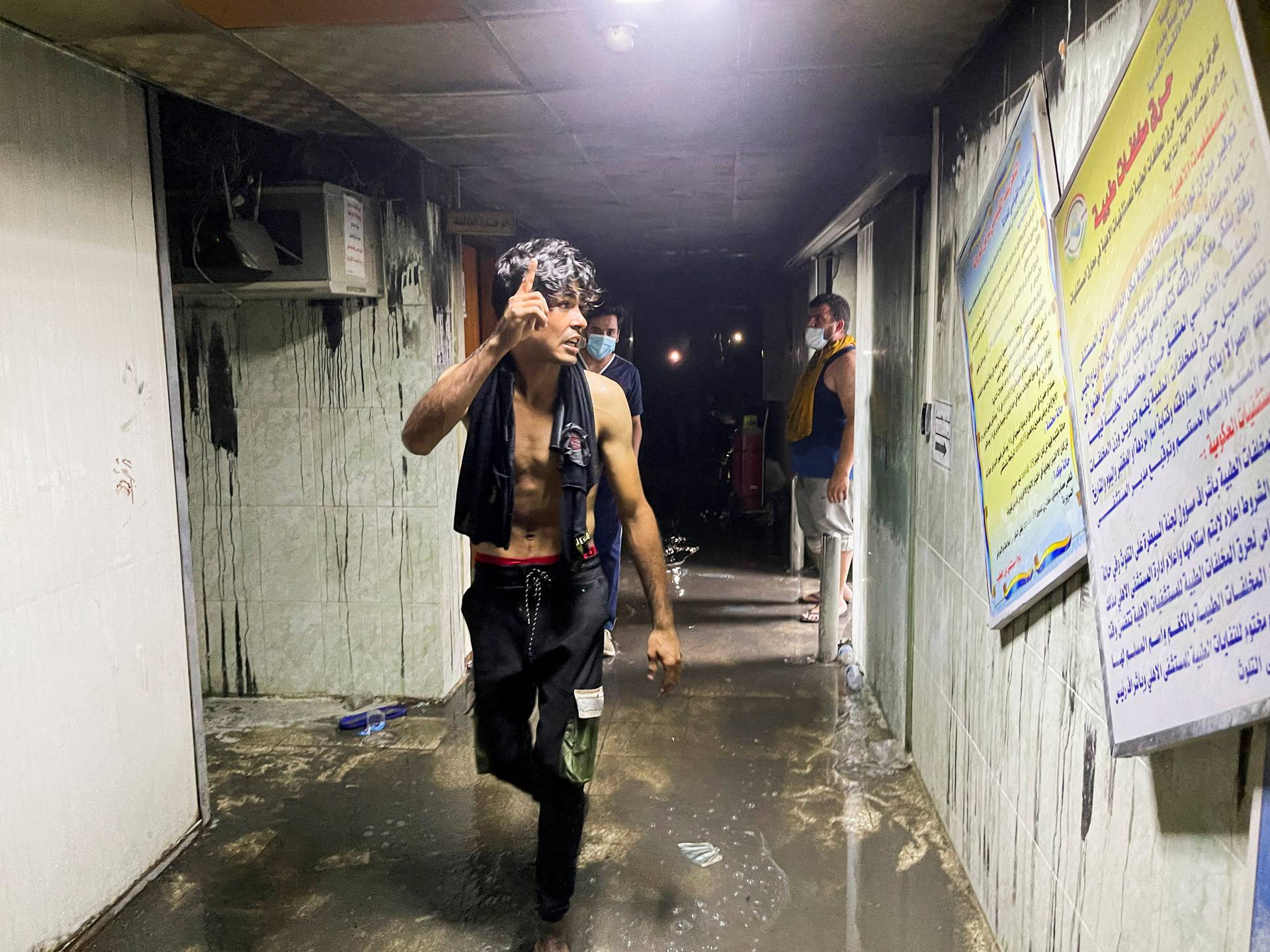 People walk at Ibn Khatib hospital after a fire caused by an oxygen tank explosion in Baghdad