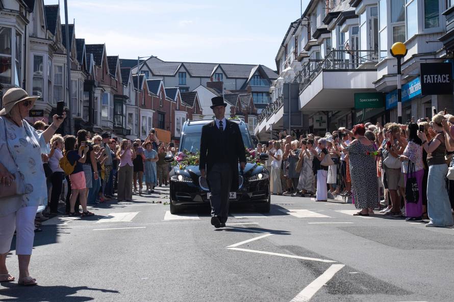 Crowds line the route in Mumbles as Bonnie Tyler's coffin makes its way to Skewen, Wales. August 15th 2026