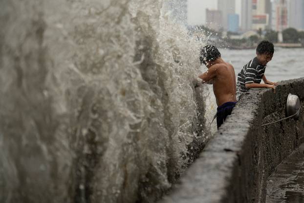 Children play near strong waves amid Super Typhoon Man-yi, in Manila