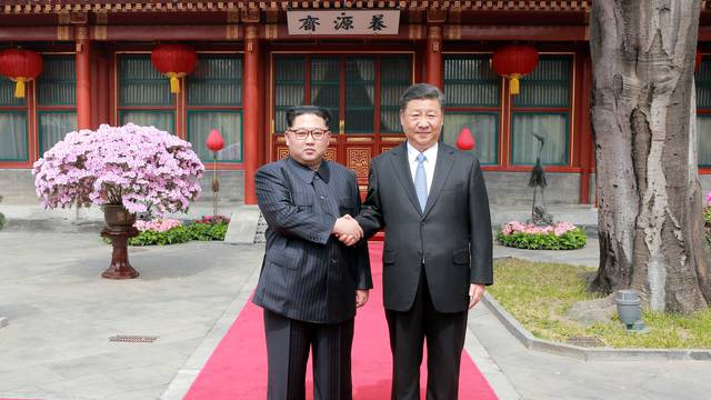 North Korean leader Kim Jong Un shakes hands with Chinese President Xi Jinping