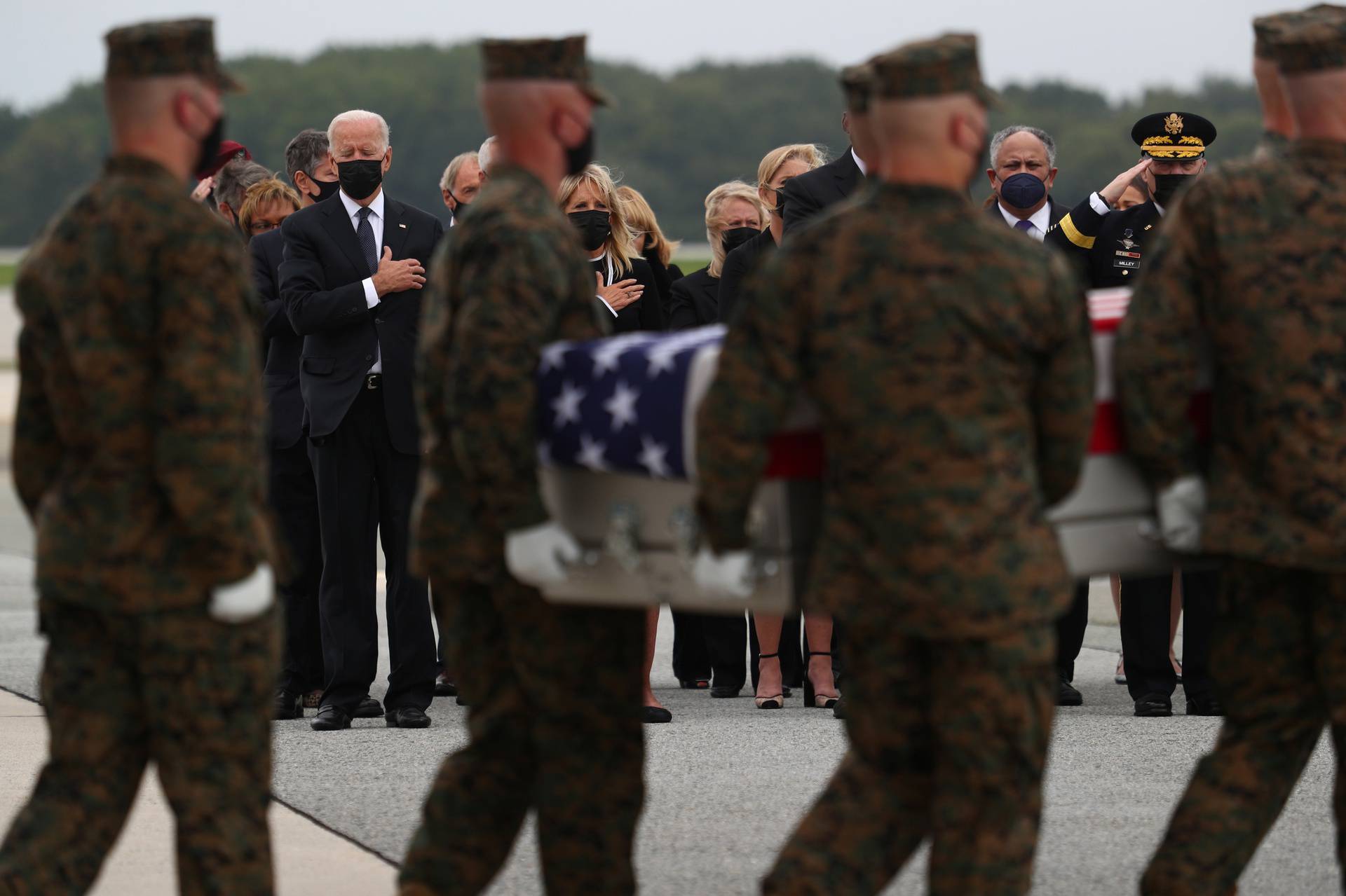 U.S. President Joe Biden salutes during the dignified transfer of the remains of U.S. Military service members who were killed by a suicide bombing at the Hamid Karzai International Airport