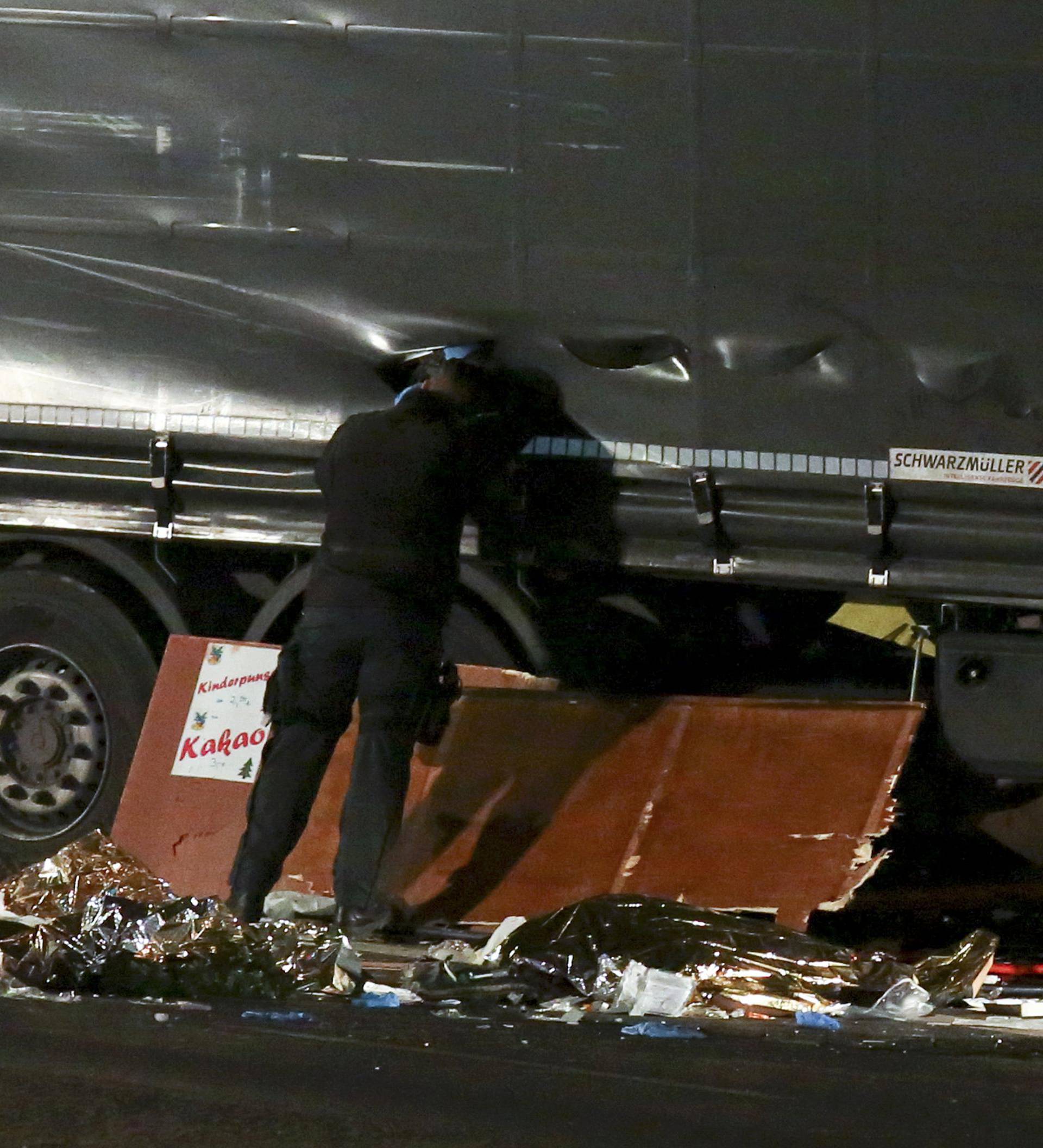 A German police officer looks into a truck at a Berlin Christmas market following an accident