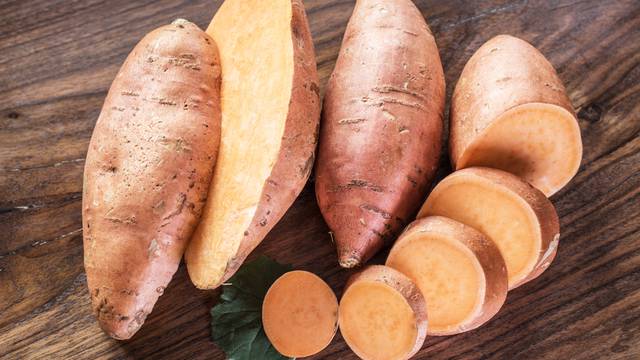 Sweet potatoes on the old wooden table.