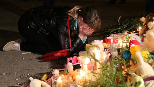 A mourner reacts at a makeshift memorial near the scene of a fatal attack on a college in Kerch