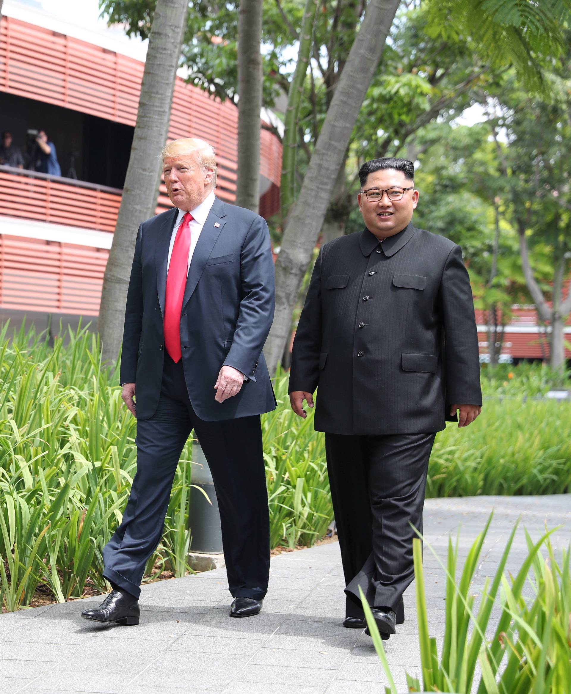 U.S. President Donald Trump and North Korean leader Kim Jong Un walk after lunch at the Capella Hotel on Sentosa island in Singapore