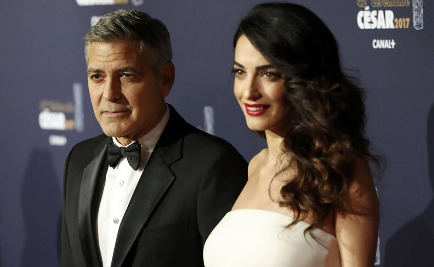 Actor George Clooney and his wife Amal pose as they arrive at the 42nd Cesar Awards ceremony in Paris