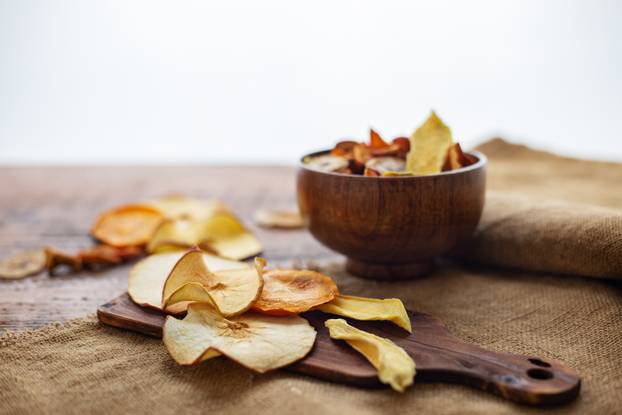 Organic assorted dried fruit snacks in bowl on wooden background