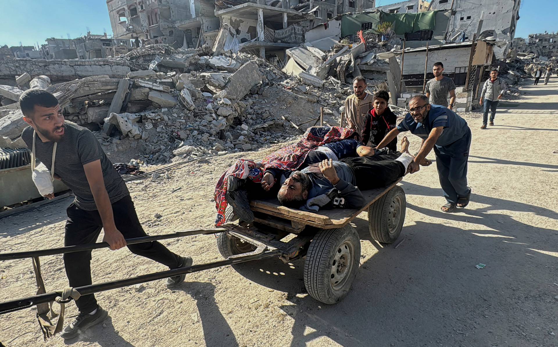 Palestinians assist casualties following an Israeli strike, in Beit Lahiya