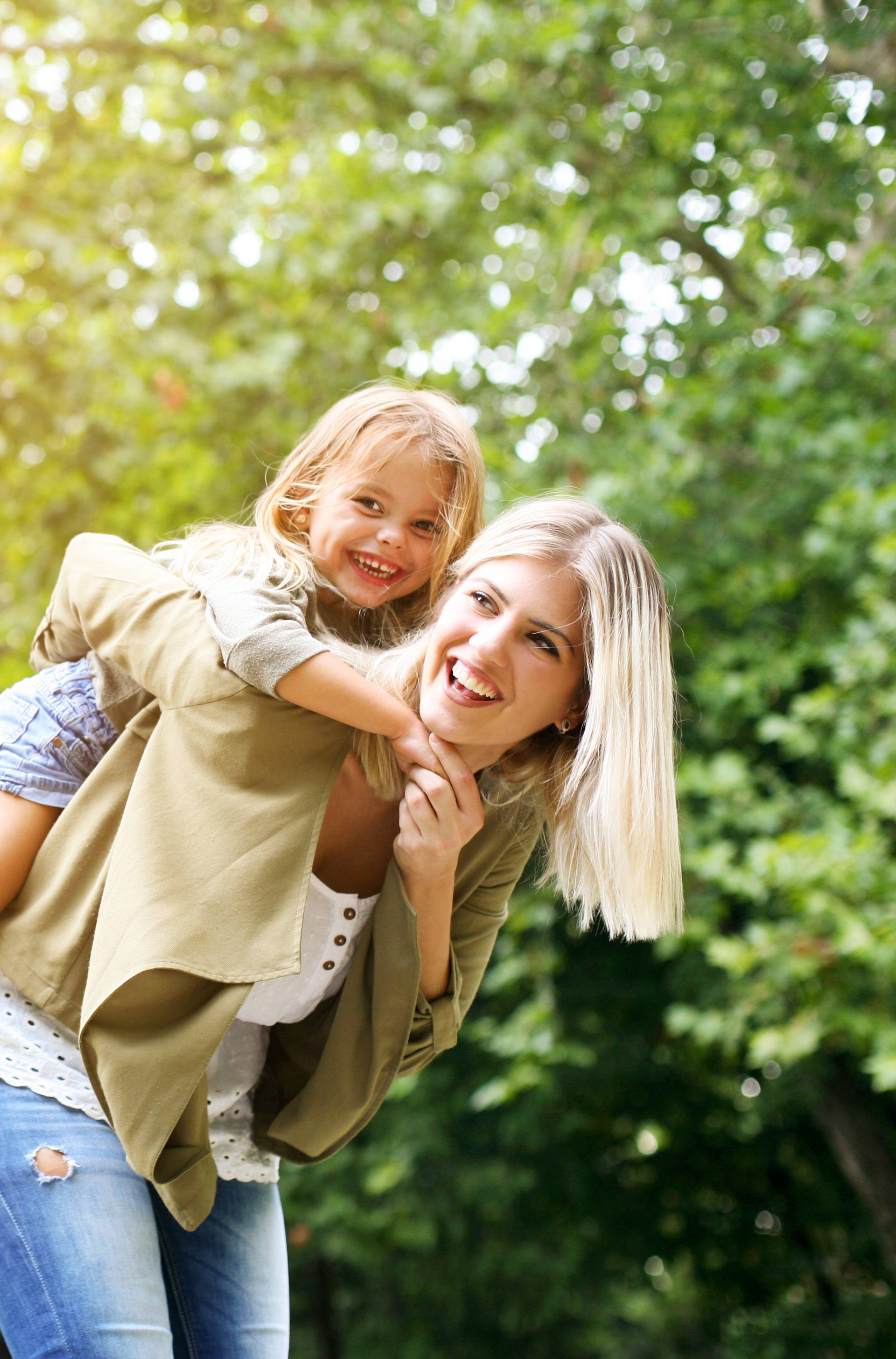 Little girl on a piggy back ride with her mother.