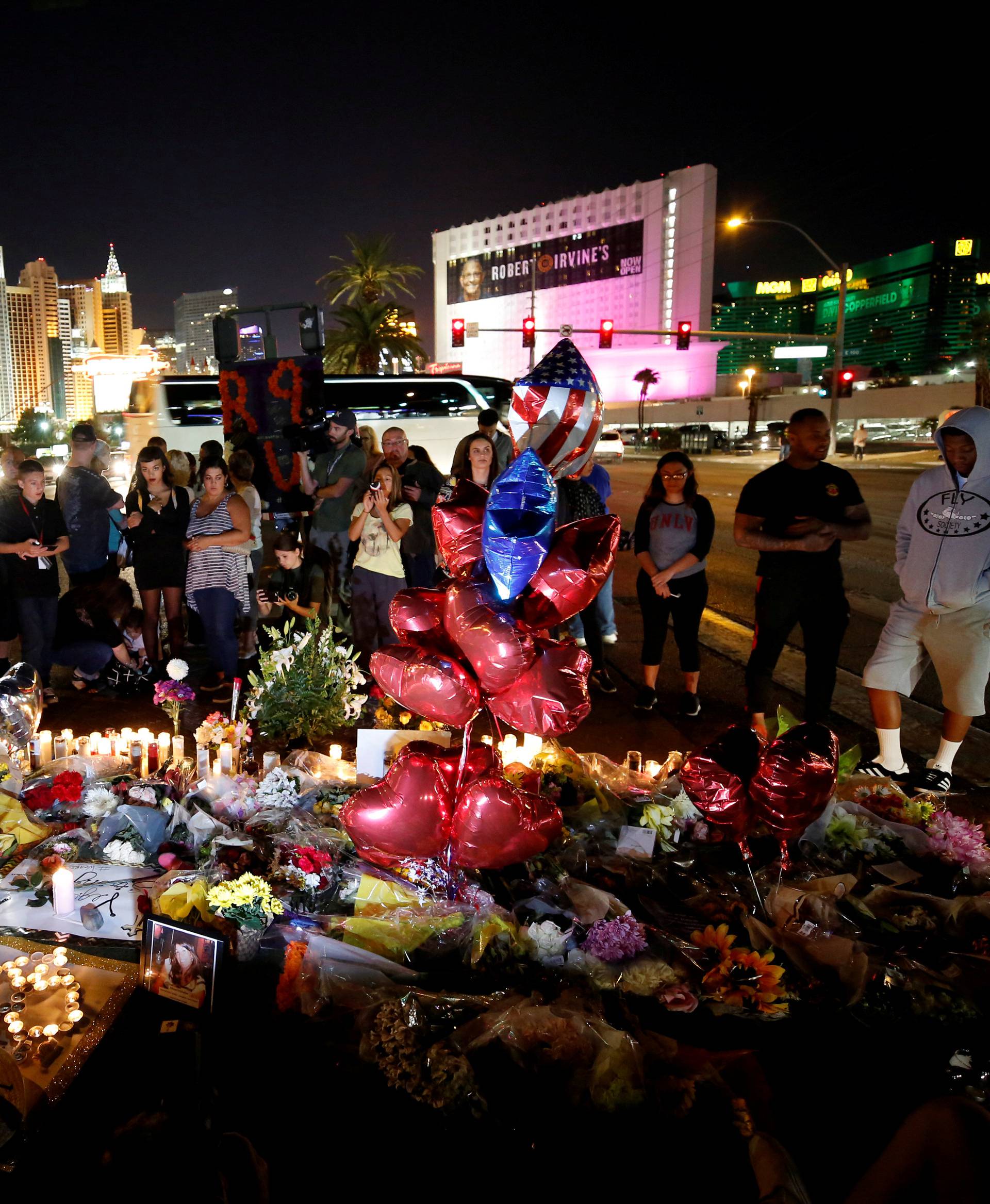 People gather at a makeshift memorial in the middle of Las Vegas Boulevard following the mass shooting in Las Vegas